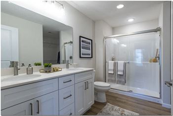 a white bathroom with a shower and a sink